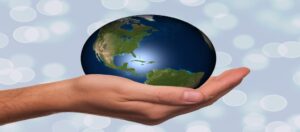 A hand holding a globe symbolizing international mobility and the changing landscape of U.S. work visas under the L1 VISA vs H1B debate.