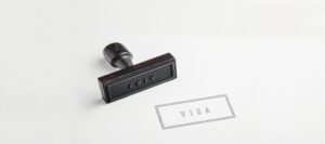 Close-up of a visa stamp and the word “Visa” printed on a document.