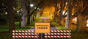 A park gate with a "temporarily closed" sign and closure markers, symbolizing halted services during the 2025 U.S. government shutdown.
