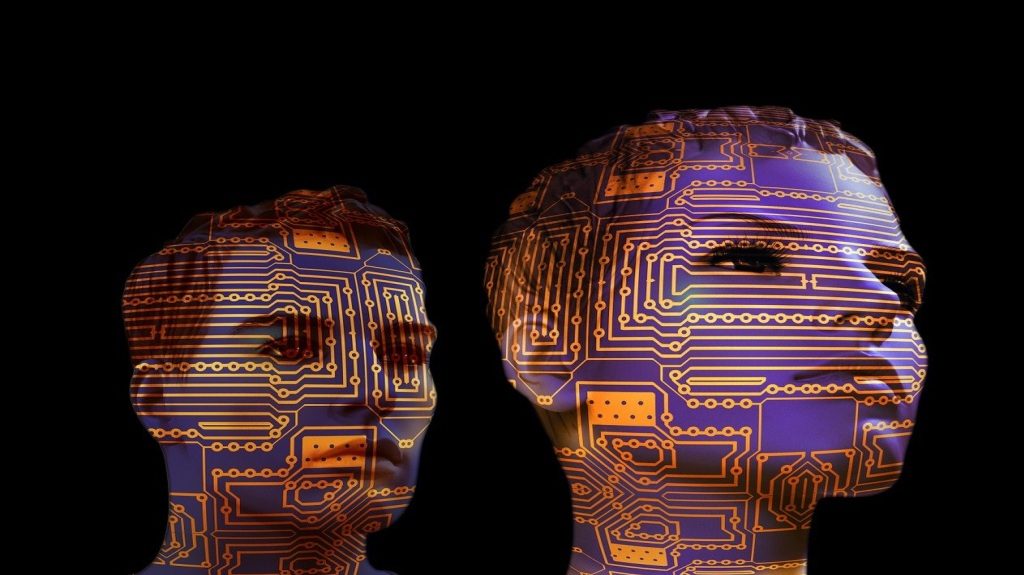 Two human faces covered in circuit board patterns symbolizing the integration of human intelligence and digital systems.