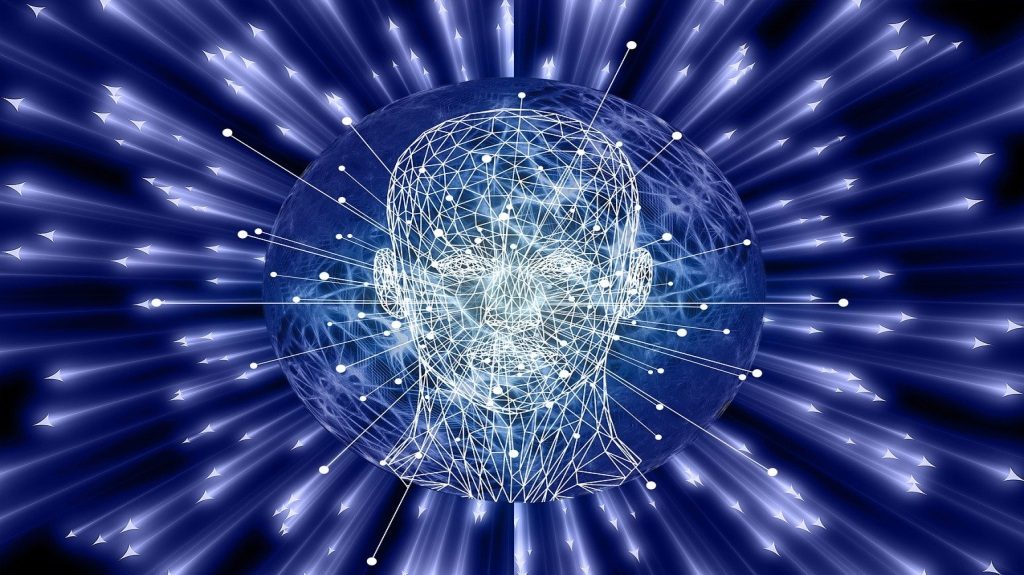 A glowing wireframe human head surrounded by light beams, symbolizing data networks, intelligence, and the future of AI.
