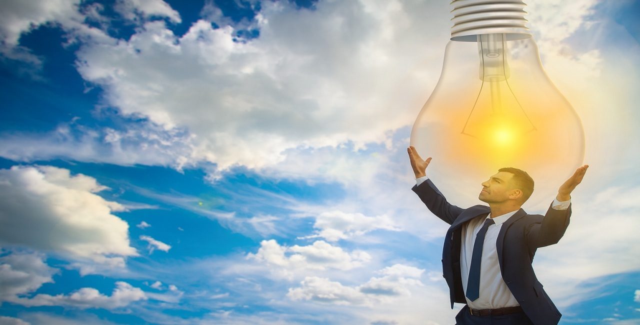 Business professional holding a light bulb symbolizing innovation and energy leadership