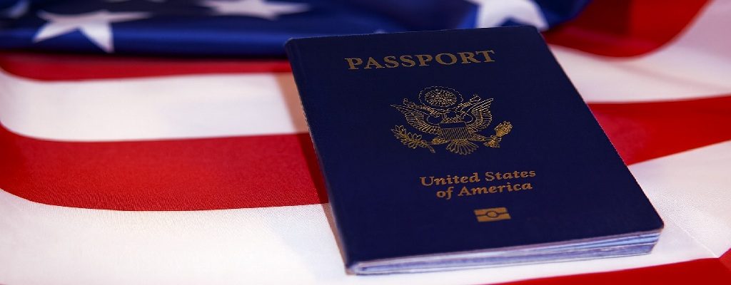A close-up of a U.S. passport with the American flag in the background, symbolizing the enduring value of citizenship by birth.