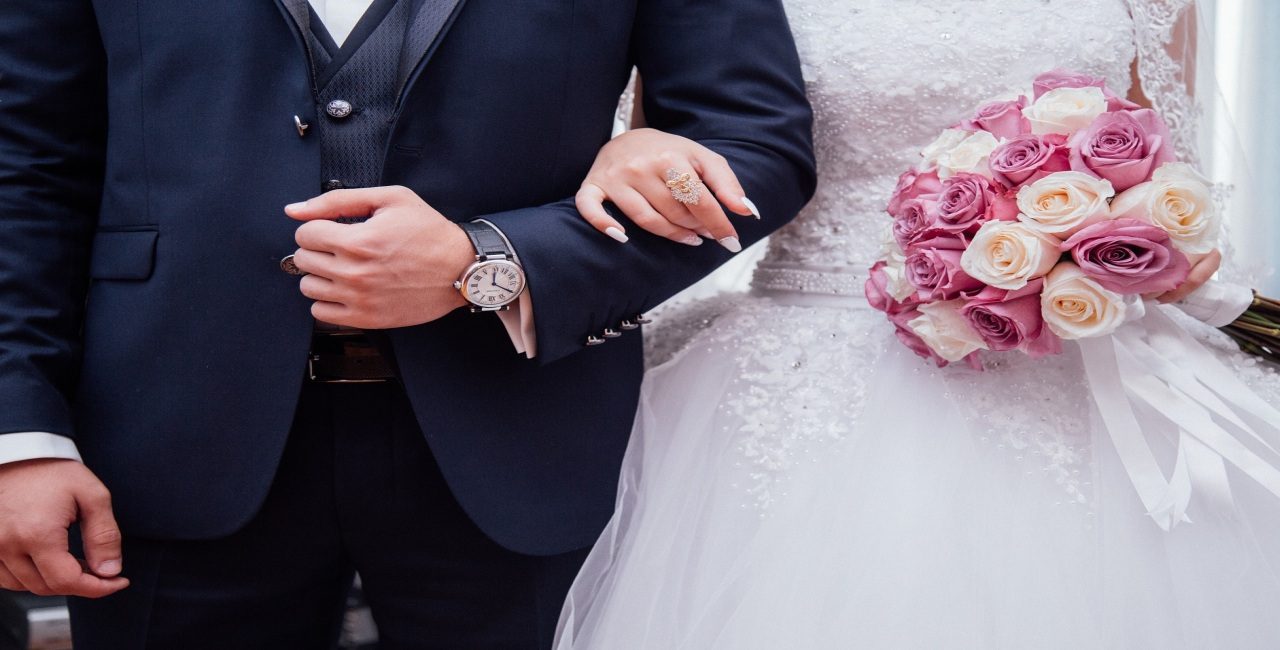 Pareja recién casada con un ramo de flores que simboliza el proceso de Green Card por matrimonio.