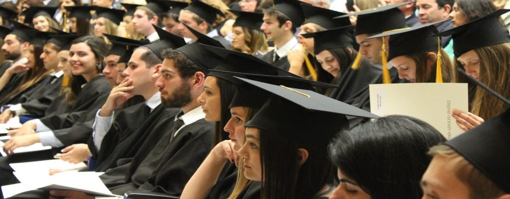 A group of students in graduation gowns and caps seated in rows, symbolizing student immigration under U.S. Immigration Visa programs.
